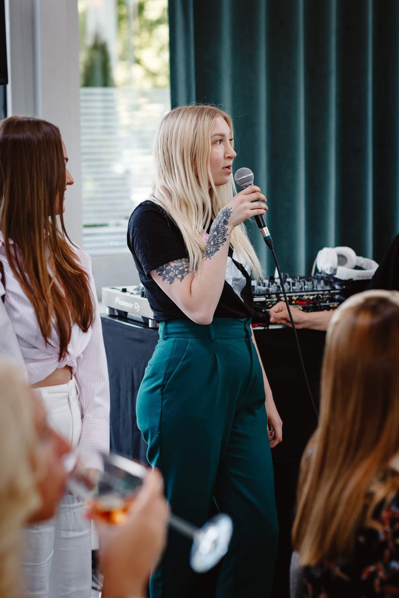 Anu speaking into a microphone at a conference